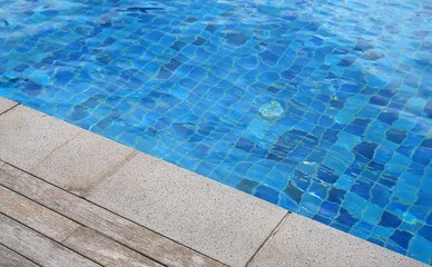 Wooden plank and cement foreground at swimming pool.