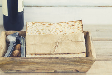 Pack of matzah or matza and Kosher red wine on a vintage wood and blurry or bokeh background.Jewish Passover holiday composition with copy space.