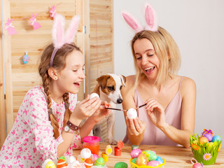 Happy woman with child paint easter eggs