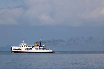 Fototapeta na wymiar Ferry sailing in the sea and pollution from the engine