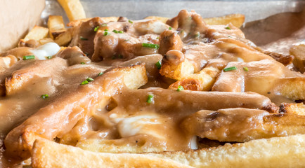 Melted cheest covered fries topped with chive slices.