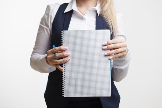 Businesswoman with notepad or organizer shows something. On a white background.