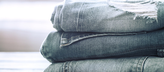 A stack of jeans on a wooden background