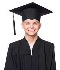 Close up portrait of graduate teen boy student in black graduation gown with hat - isolated on white background. Child back to school and educational concept.