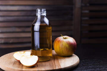 fresh apple drink in a glass bottle wooden background