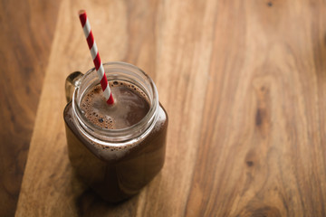 warm cocoa in jar mug on a wooden table