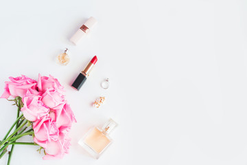 Bouquet of pink roses and women's accessories on white background