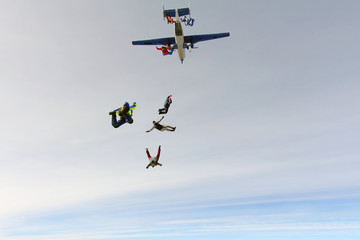 Skydivers are jumping out of a plane.