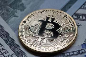 Fototapeta na wymiar Close-up of gold coin bitcoin on dollar bills