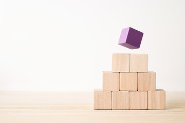 Business and design concept - abstract geometric real wooden cube with surreal layout on white floor background and it's not 3D render. It's the symbol of leadership, teamwork and growth