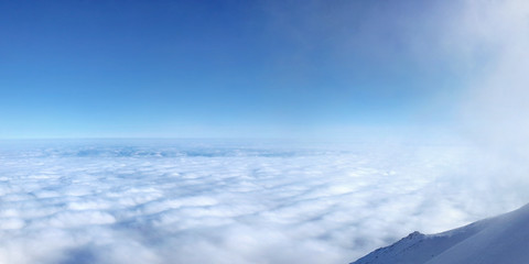 Temperature inversion forming sea of clouds seen from above, high in mountains. Lomnicke sedlo ski resort. Slovakia
