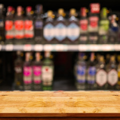 Empty top of wooden table with blurred counter bar and bottles Background.