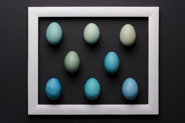 Happy Easter black and white background. DIY dyed shades of blue Easter eggs abstract minimal concept.