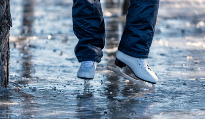 Female ice skates on the ice in the park
