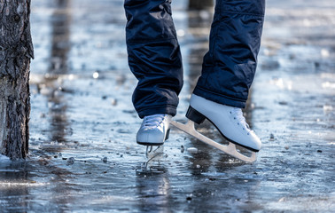 Female ice skates on the ice in the park