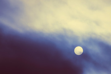 Cold sun shines through thick fog in overcast weather.