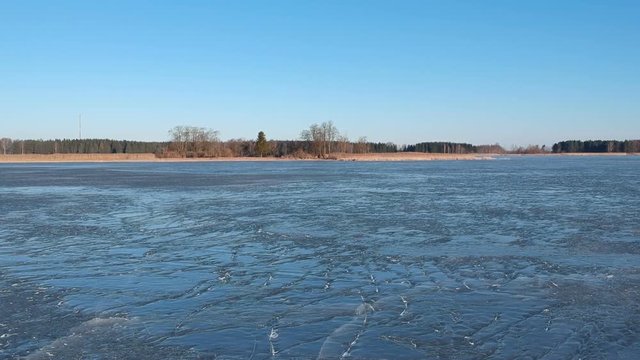 Drone fly above cracked spring time lake ice, aerial view