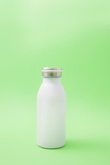 White thermo bottle on a green background