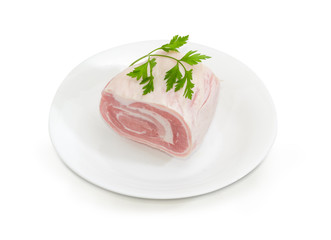 Uncooked streaky pork belly on a white dish