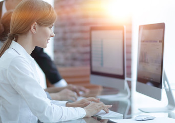 employees working on personal computers with financial data