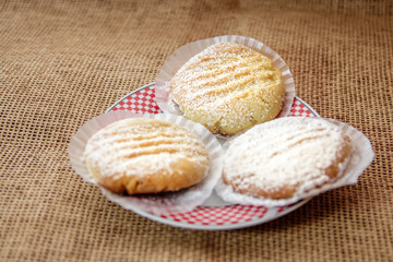 Three Homemade or table food cookies on white plate with burlap textile. Close up shot.