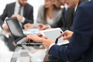 Business man using a tablet  while business people talking in th