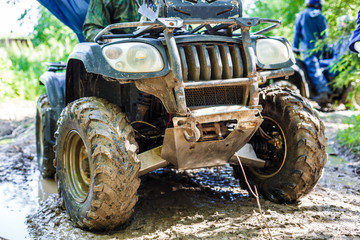 Fototapeta na wymiar Group of young people riding ATV on dirt track