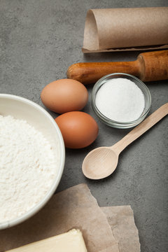 Wheat flour in bowl, milk in a glass jar, chicken eggs - vertical.