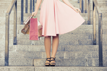 Slender women's legs with paper bags