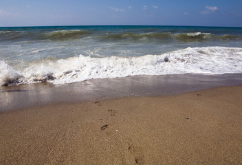 Human footprints lead to the raging sea.