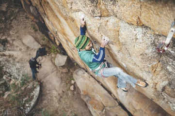 High angle view of climber reaching across for handhold on rock face in granite wall
