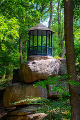 Photo of wooden gazebo in a green park at summer