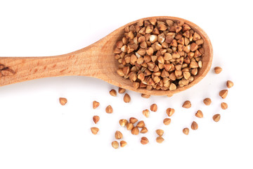 buckwheat grain in wooden spoon isolated on white background close up. Top view