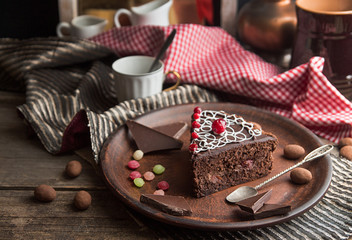 Piece of chocolate cake on plate on wooden background.