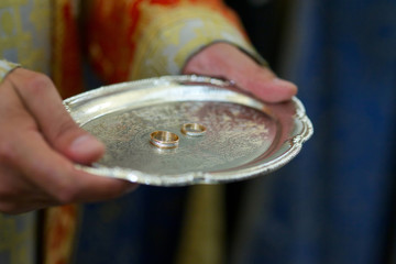 A Christian priest holds in his hands a wedding ring.