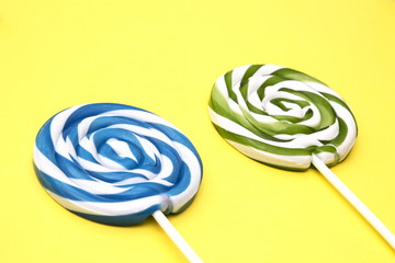 colorful spiral lollipops on yellow background