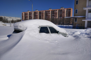 parked car in the city completely covered with snow