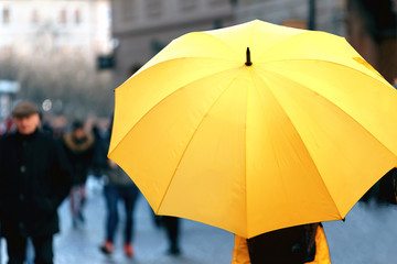 Big yellow umbrella on the city street. Place for text. The view from the top