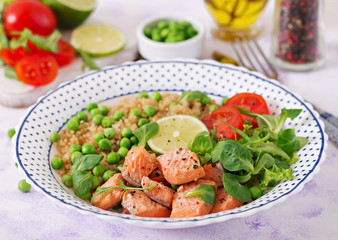 Healthy dinner. Slices of grilled salmon, quinoa, green peas, tomato, lime and lettuce leaves