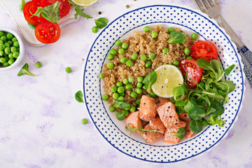 Healthy dinner. Slices of grilled salmon, quinoa, green peas, tomato, lime and lettuce leaves. Flat lay. Top view