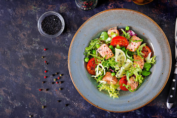 Healthy salad with fish. Baked salmon, tomatoes, lime and lettuce. Healthy dinner. Flat lay. Top view