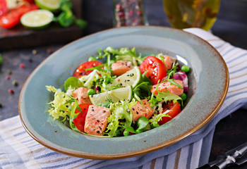 Healthy salad with fish. Baked salmon, tomatoes, lime and lettuce. Healthy dinner.