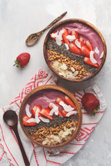 Vegan breakfast concept. Strawberry smoothie bowl with almonds, chia, sprouts and coconut, top view, copy space.