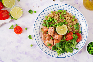 Healthy dinner. Slices of grilled salmon, quinoa, green peas, tomato, lime and lettuce leaves. Flat lay. Top view