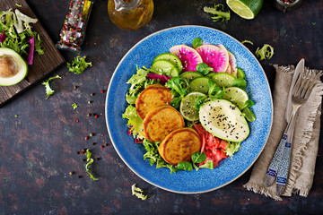 Vegan buddha bowl dinner food table. Healthy food. Healthy vegan lunch bowl. Fritter with lentils and radish, avocado salad. Flat lay. Top view