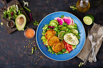 Fototapeta na wymiar Vegan buddha bowl dinner food table. Healthy food. Healthy vegan lunch bowl. Fritter with lentils and radish, avocado salad. Flat lay. Top view