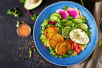 Vegan buddha bowl dinner food table. Healthy food. Healthy vegan lunch bowl. Fritter with lentils and radish, avocado salad. Flat lay. Top view