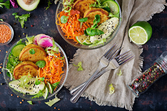 Vegan buddha bowl dinner food table. Healthy food. Healthy vegan lunch bowl. Fritter with lentils and radish, avocado, carrot salad. Flat lay. Top view
