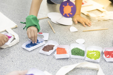 Close up hands of a kids drawing on paper  with many color