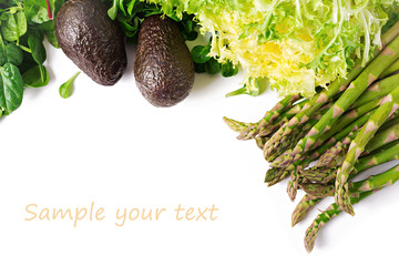 Green herbs, asparagus and black avocado on a white  background. Top view. Flat lay